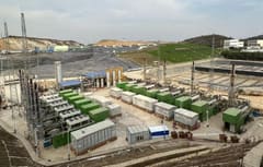 Row of gas genset containers with SCR systems at a landfill site, further photo