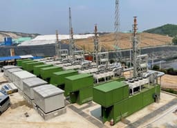 Row of gas genset containers with SCR systems at a landfill site