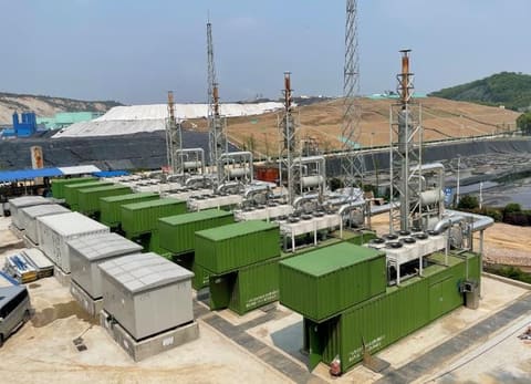 Row of gas genset containers with SCR systems at a landfill site